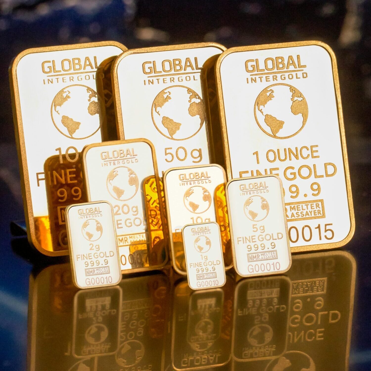 IBGCN.org Collection of gold bars featuring a global map and weight inscriptions.